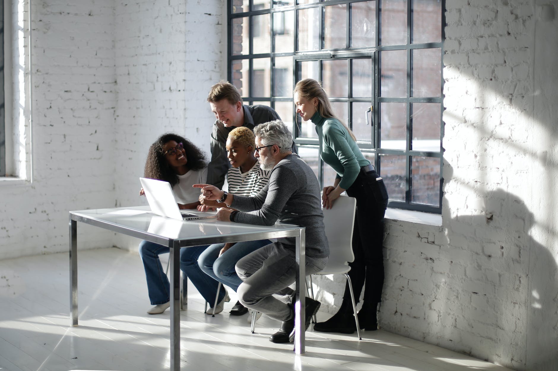 team of creative colleagues using laptop for working on project