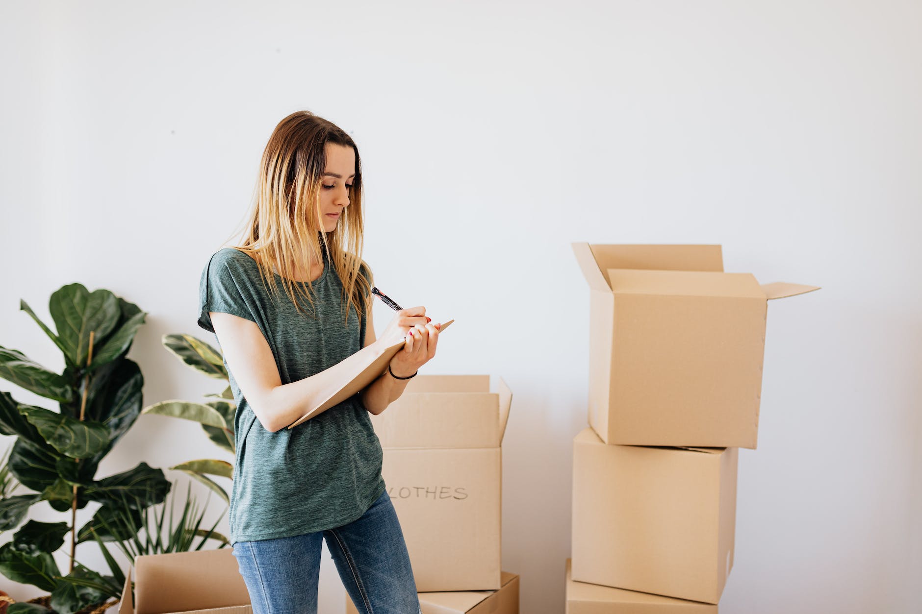 glad woman writing down notes during while packing