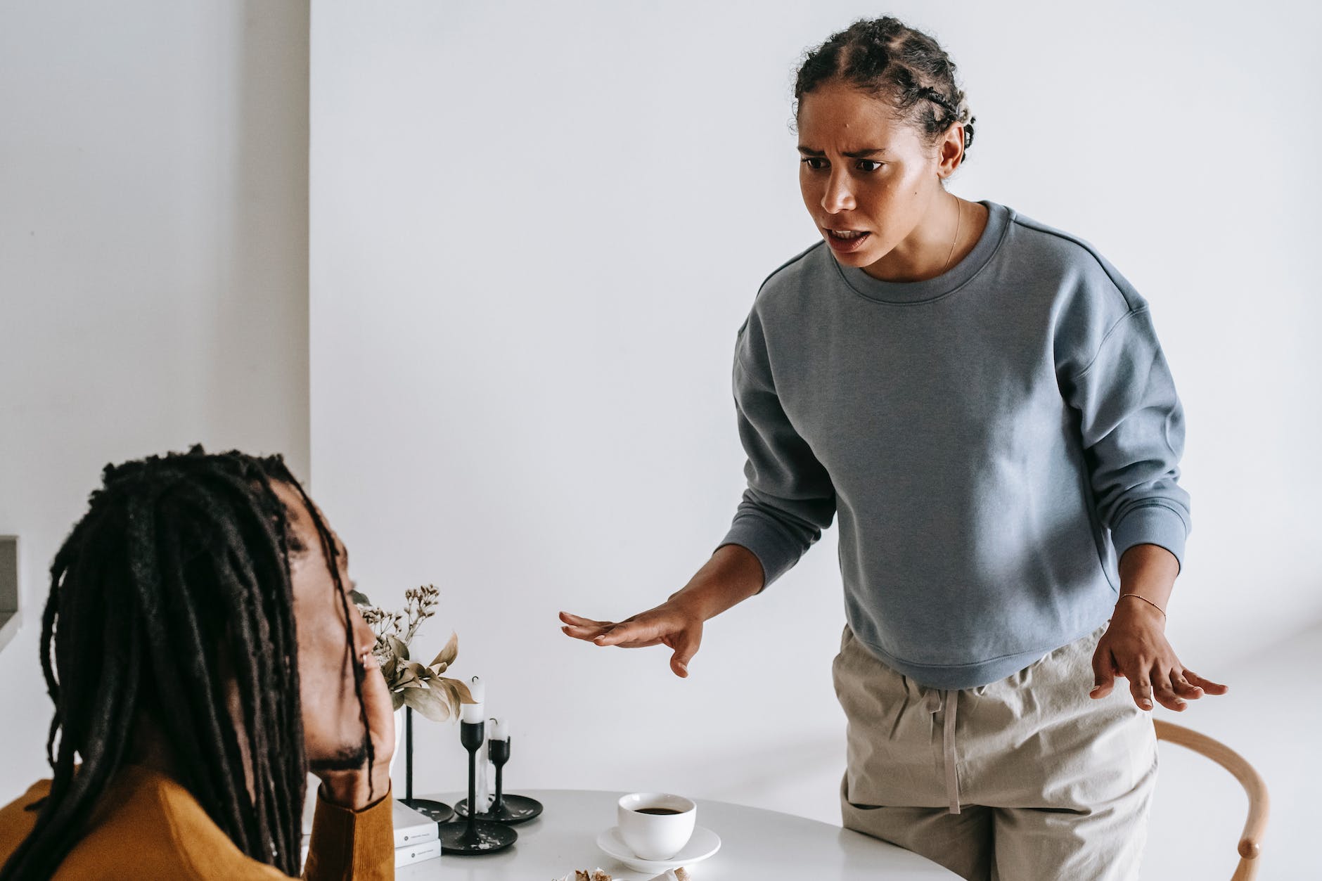 nervous young black woman quarreling with husband during breakfast in kitchen