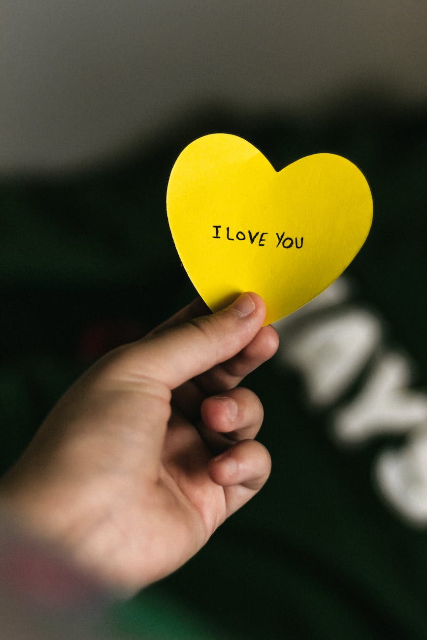 a person holding a heart shaped paper