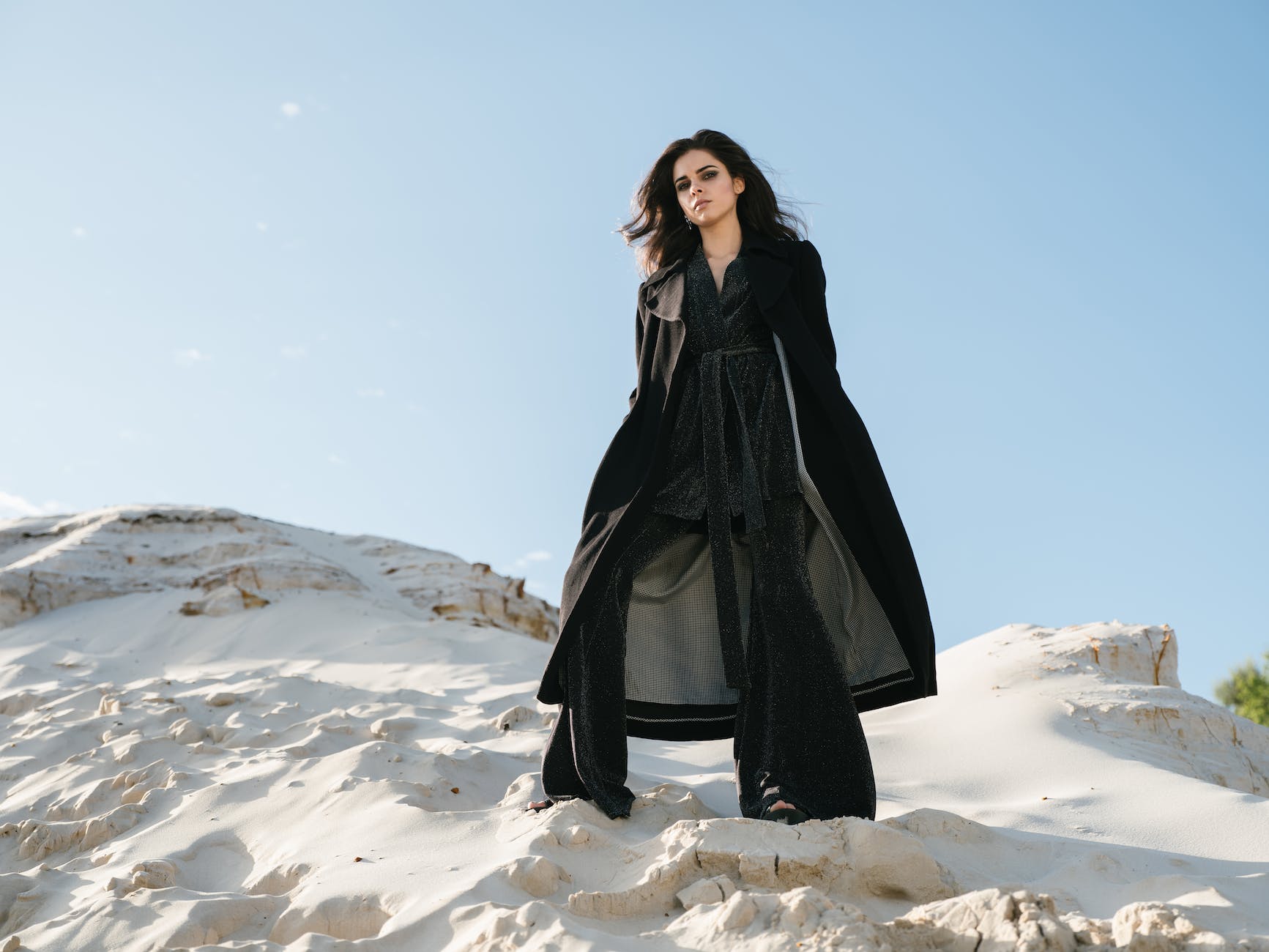 stylish woman standing on sandy slope