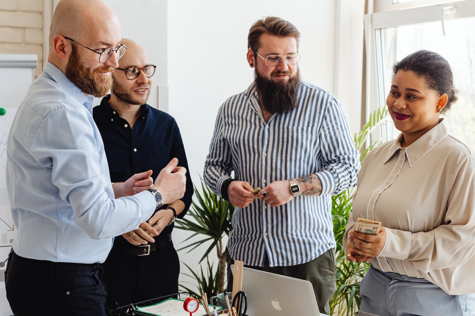 men looking at a woman holding cash at an office